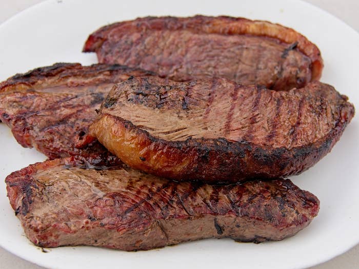 Grillede biffer anordnet på en hvit plate, som viser røyemerker og brunede kanter