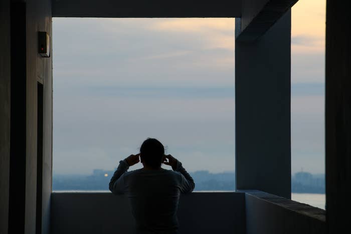 Personen står på en balkong og tar et bilde av byens skyline i skumringen
