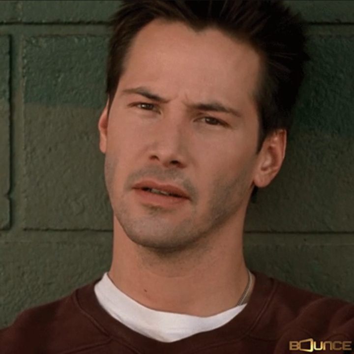 En person med kort hår er mot en murvegg, iført en uformell topp og ser ettertenksom