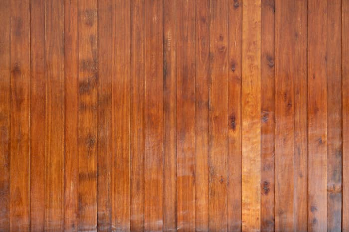Treplankvegg med vertikale paneler og synlig korntekstur