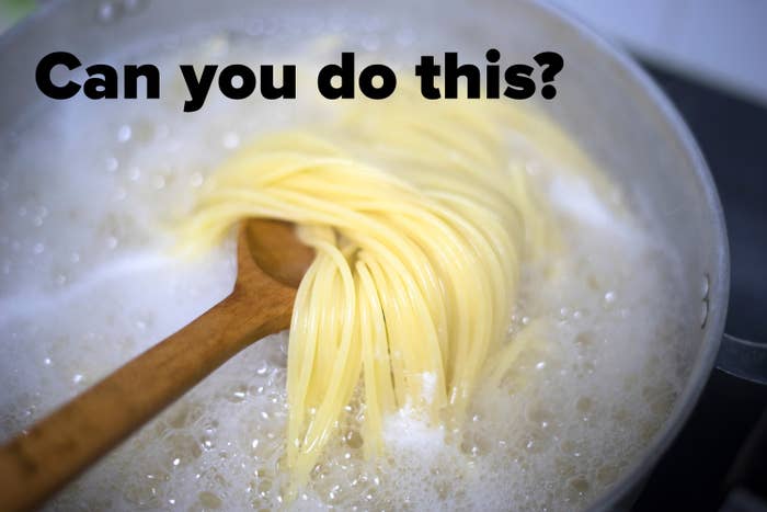 Pasta som kokes i kokende vann, omrørt med en tresleiv i en gryte