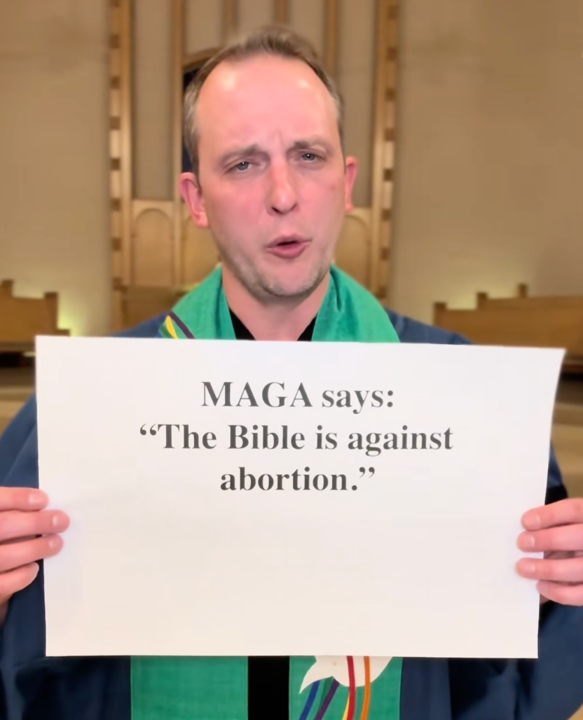 En person holder et skilt der det står, "MAGA sier: 'Bibelen er imot abort.'"