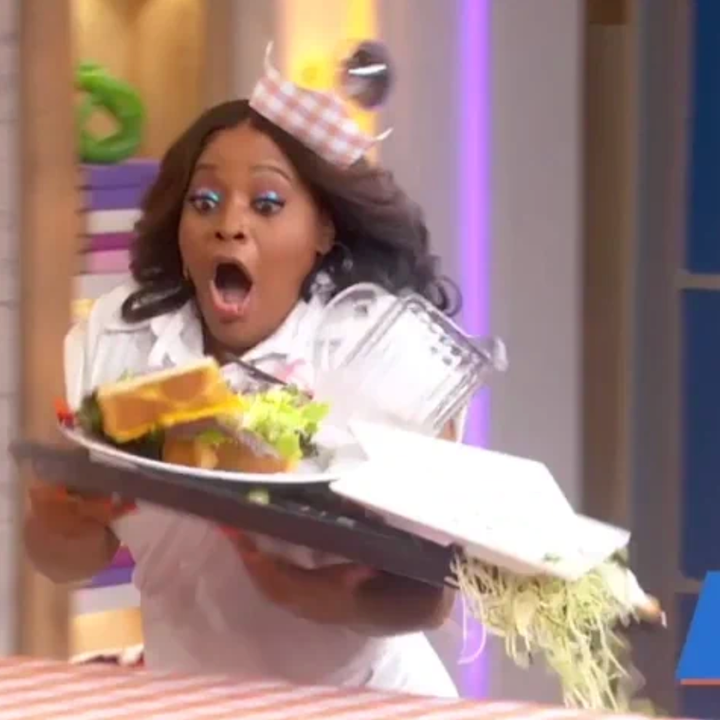 En overrasket person slipper et brett med mat, med munnen åpen i sjokk