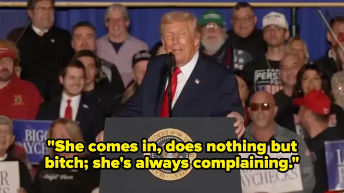 En offentlig person taler ved et podium med en folkemengde som holder skilt som sier «Større lønnsslipper»; i bakgrunnen