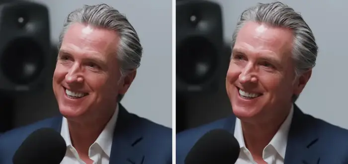 Person som smiler under et podcastintervju. De har på seg en dressjakke over en skjorte og snakker i en mikrofon