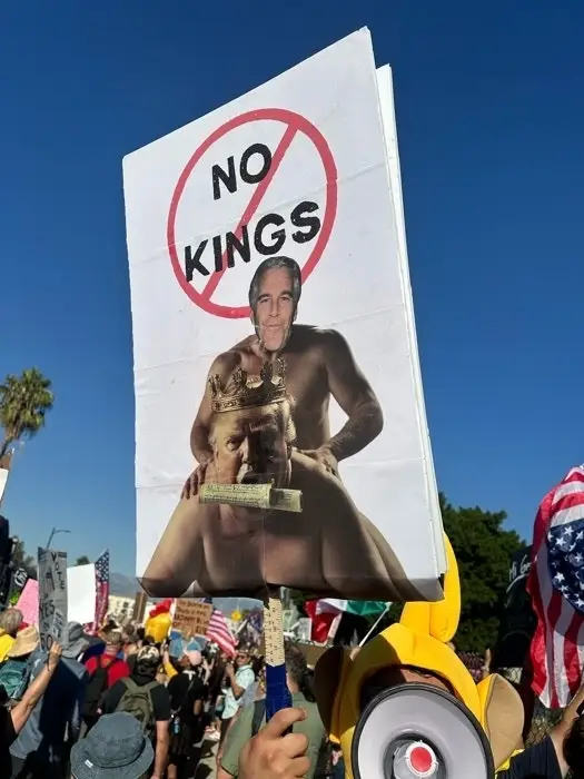 Protestskilt med endret bilde av to figurer, merket 