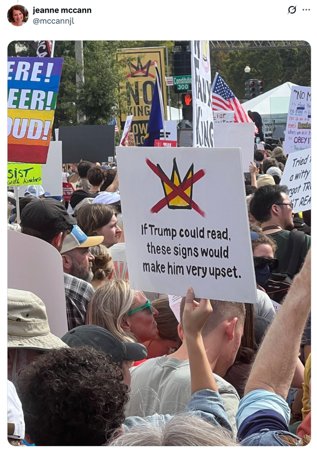 Folkemengde ved en protest med en person som holder et skilt som sier: 