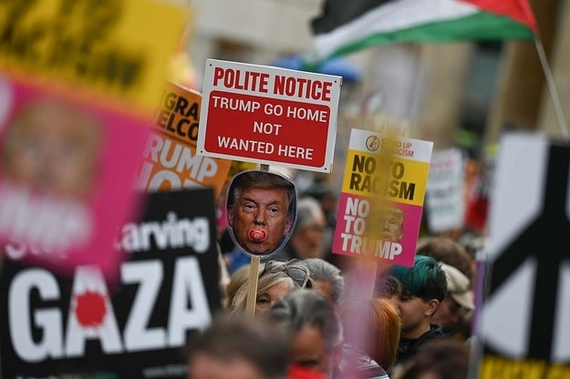 Demonstranter som holder anti-Trump og anti-rasisme-skilt, inkludert en 