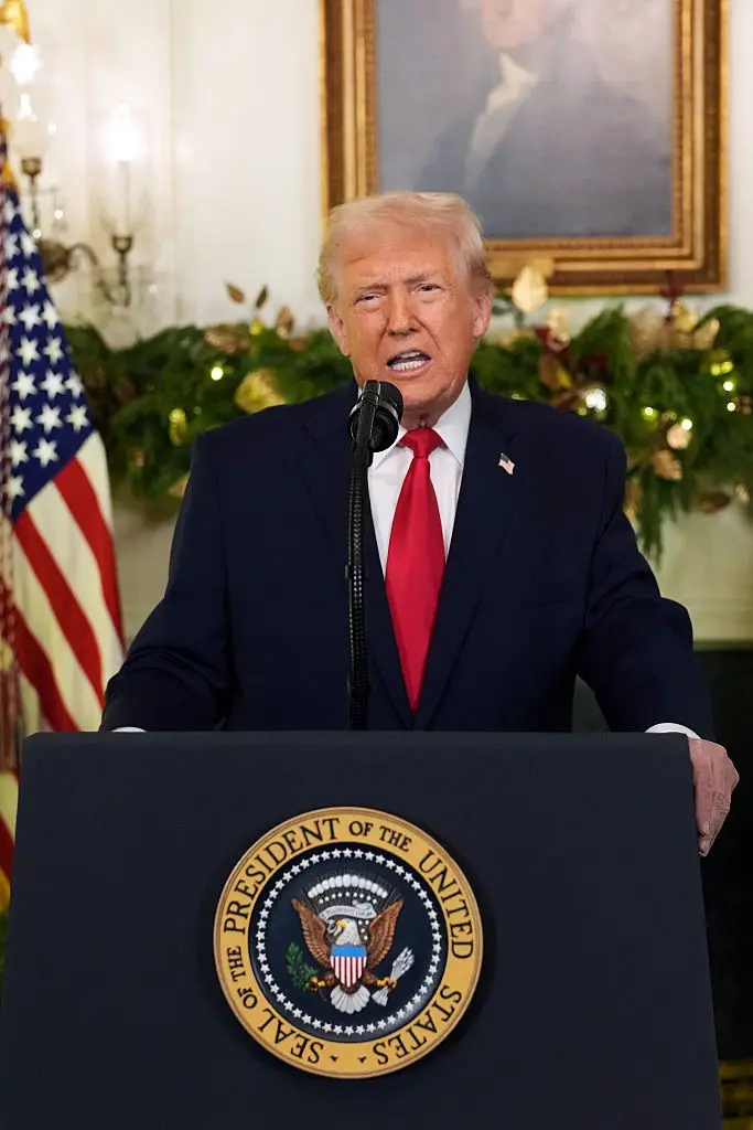 En person som snakker på et podium med seglet til presidenten i USA, satt i et formelt rom med amerikansk dekor