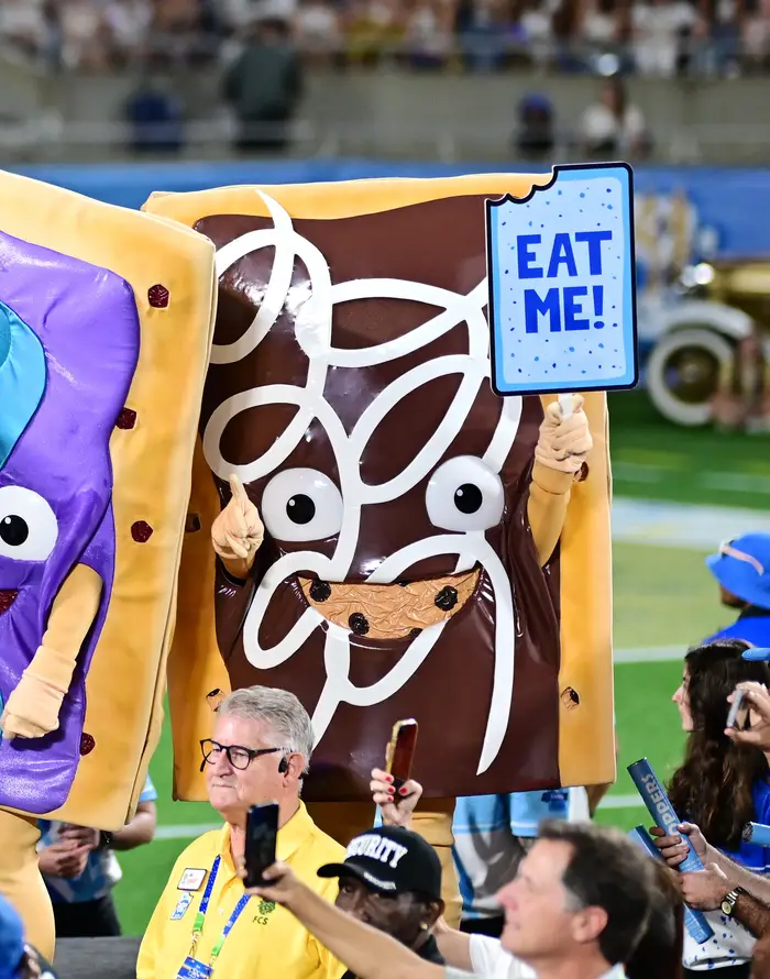 Karakterer kledd som lekne Pop-Tart-maskoter holder skilt med teksten 