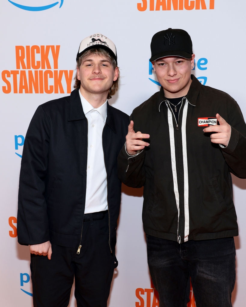 To personer poserer på en rød løper ved en 