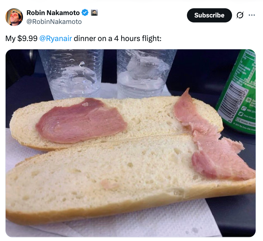 To brødskiver med en liten mengde skinke på et brett. To drinker er synlige i bakgrunnen