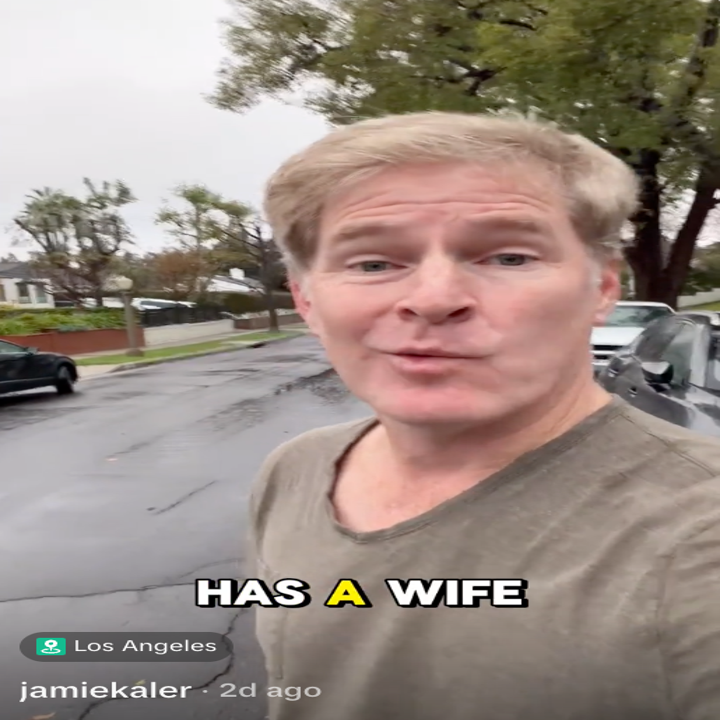 Person utendørs på en våt gate, med bildeteksten «HAS A WIFE», med beliggenhet merket som Los Angeles