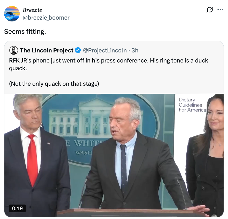 Tre personer på et podium; tekstoverlegg noterer humoristisk en and-ringetone under en pressekonferanse