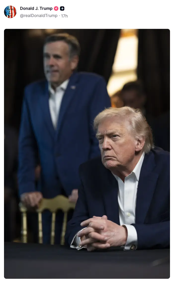 To menn i dress sitter og står, og dukker opp dypt i tanker på en begivenhet