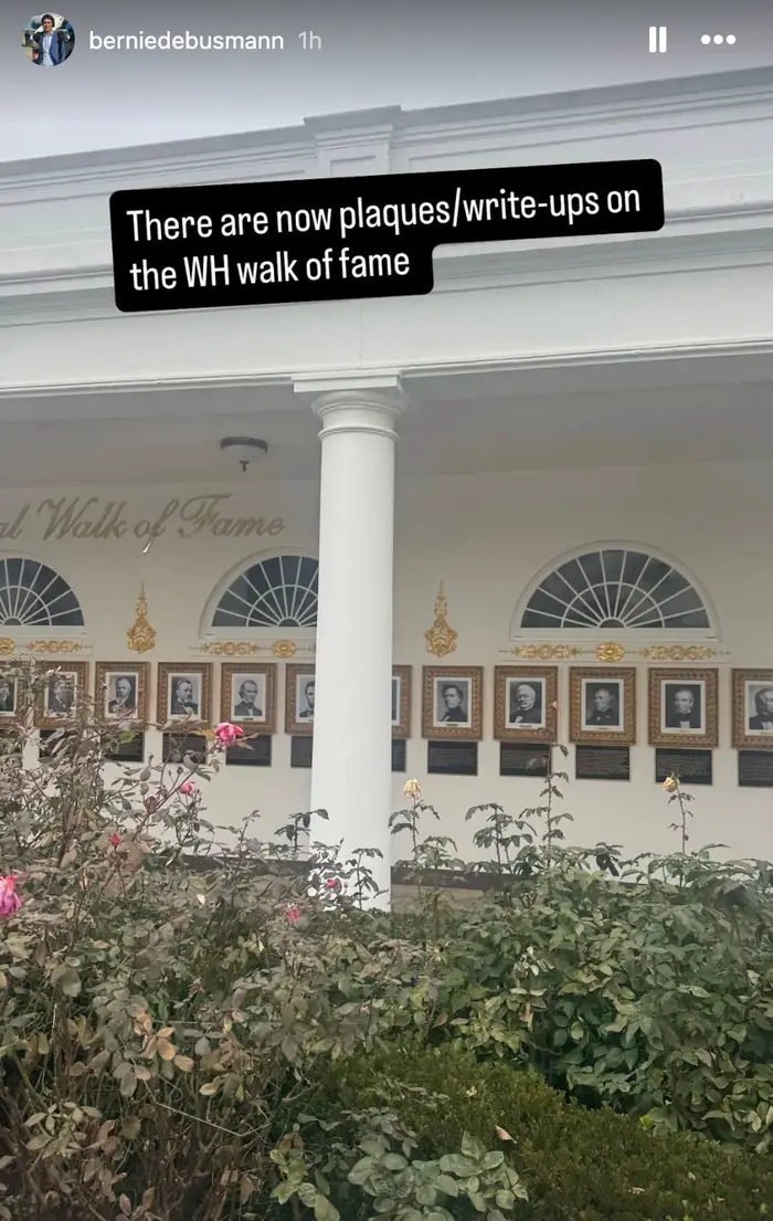 Utvendig visning av en bygning med plaketter på "WH Walk of Fame." Blomster er synlige i forgrunnen. Tekstoverlegg nevner de nye plakettene