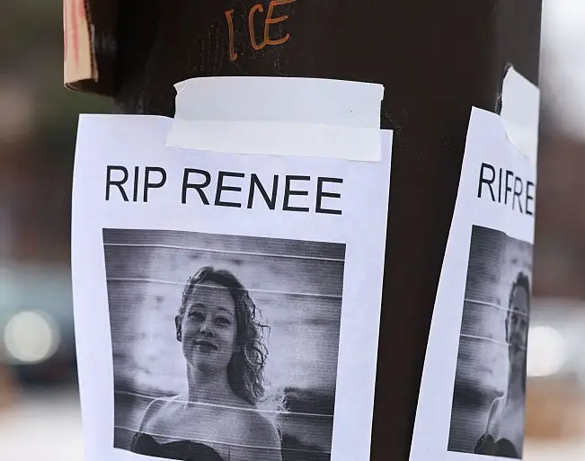 Plakater på en stang viser "RIP Renee" med "Murdered by ICE" under et svart-hvitt-bilde. Graffiti sier 