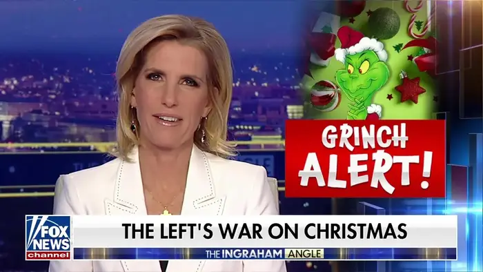 Et TV-skjermbilde viser et nyhetsanker i et studio som diskuterer "The Left's War on Christmas" med et "Grinch Alert!" grafikk på skjermen