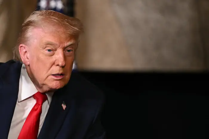 En person i dress og slips dukker opp i en formell setting og ser oppmerksom ut