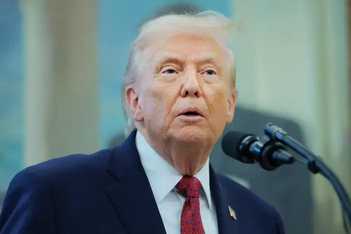 Person i dress som snakker ved en mikrofon under et arrangement