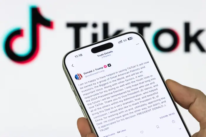 Person som holder en smarttelefon som viser et teksttungt TikTok-innlegg av en bemerkelsesverdig konto, med en TikTok-logo i bakgrunnen