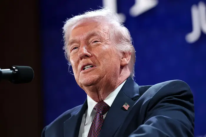 En person i dress taler ved et podium, engasjert i å holde en tale ved en bemerkelsesverdig begivenhet