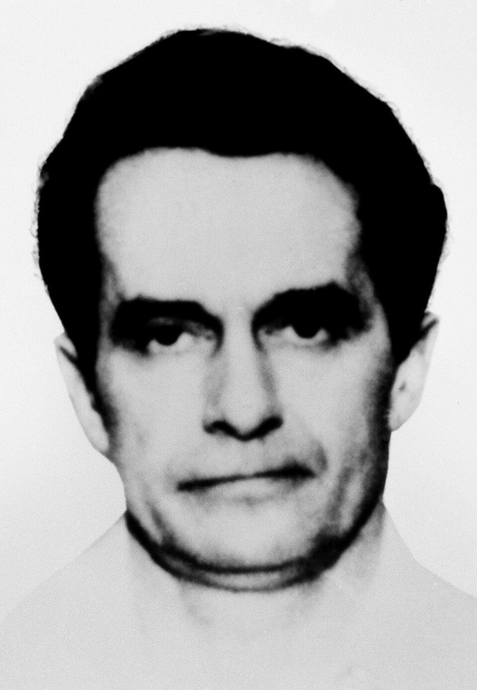 Jeg beklager, jeg vet ikke hvem denne personen er. Det er et svart-hvitt bilde av en mann med et nøytralt uttrykk, iført en skjorte med krage