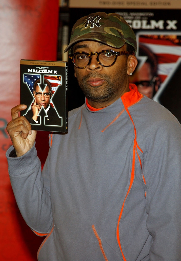 En person i briller og caps holder en DVD av