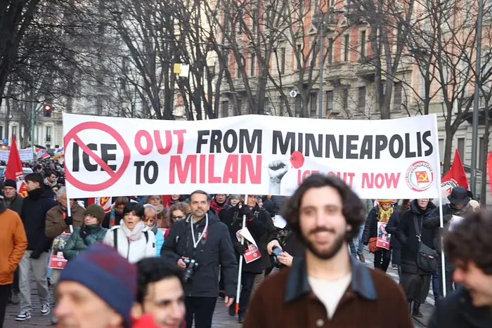 Folk som marsjerer i en protest med et banner som sier 