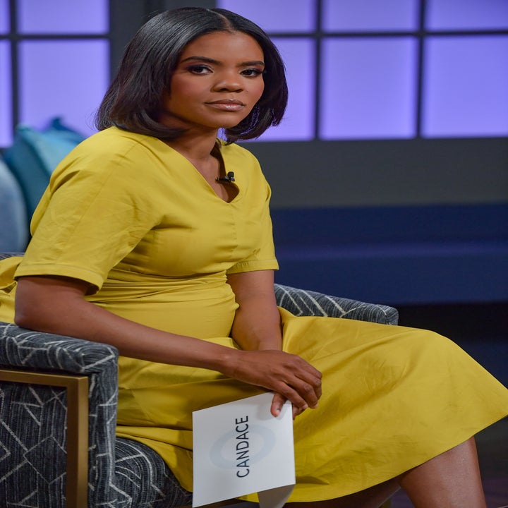 Person som sitter på et talkshow-sett, iført en knelang gul kjole, holder et notatkort