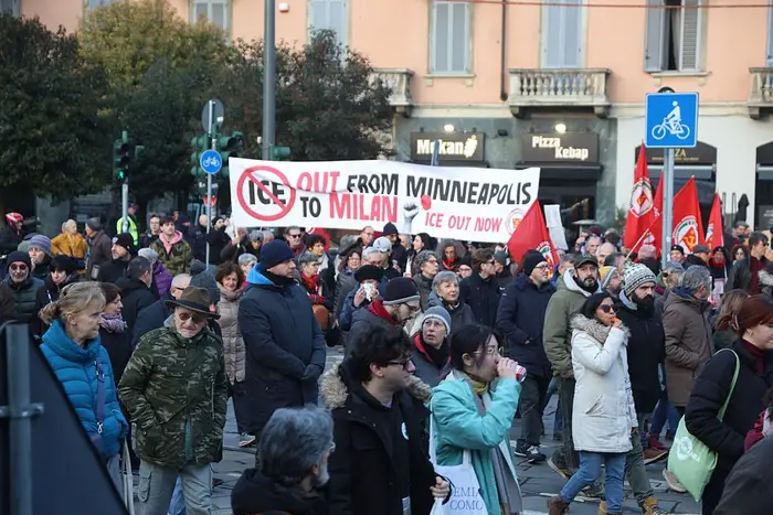Folkemengde ved en protest; folk holder bannere med teksten 