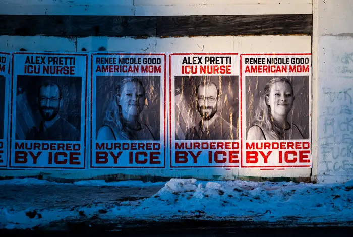 Plakater viser "Renee Nicole Good, American Mom" og "Alex Pretti, ICU-sykepleier" ovenfor "Murdered by ICE" på snødekt vegg