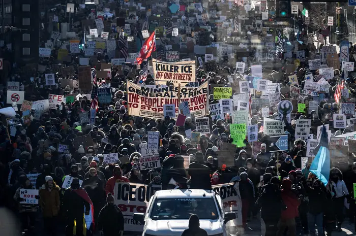 En stor mengde demonstranter som marsjerer med forskjellige skilt om arbeidstakers rettigheter og sosial rettferdighet, og fyller gaten