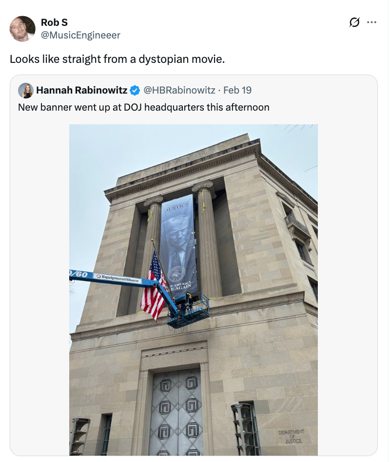 Twitter-innlegg som viser en DOJ-bygning med et stort banner som henges av en kran, som ligner en dystopisk scene