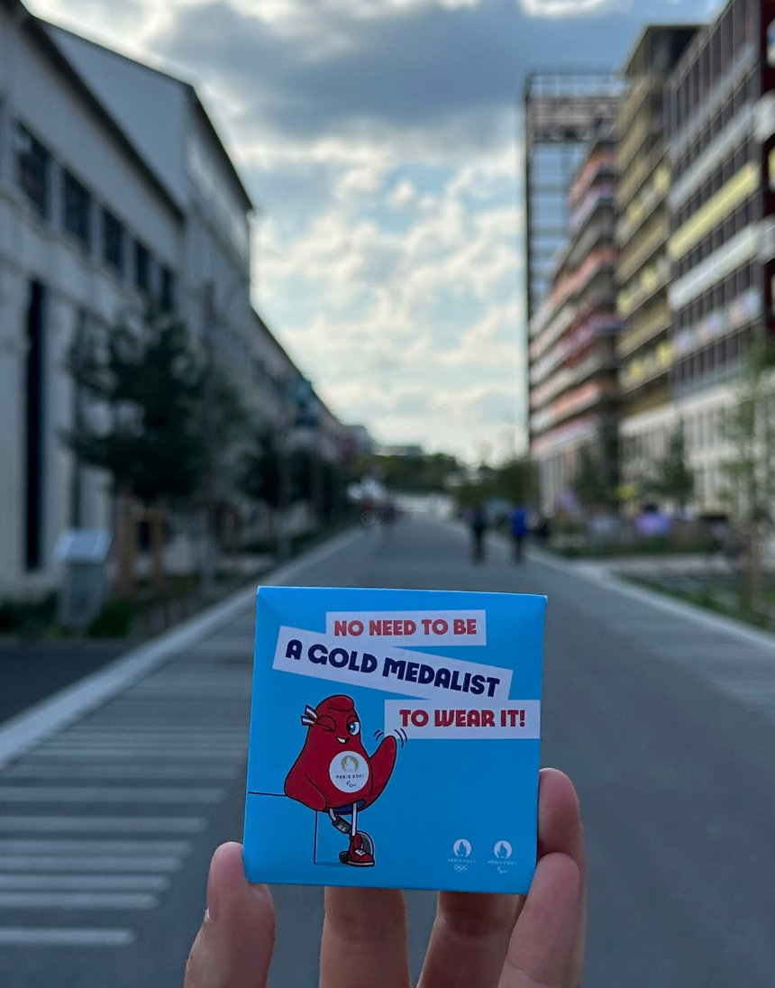 Person holder en blå boks med en tegneseriefugl og tekst: 