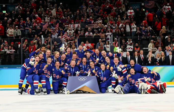 Amerikansk kvinnehockeylag feirer seier, iført uniformer utsmykket med 