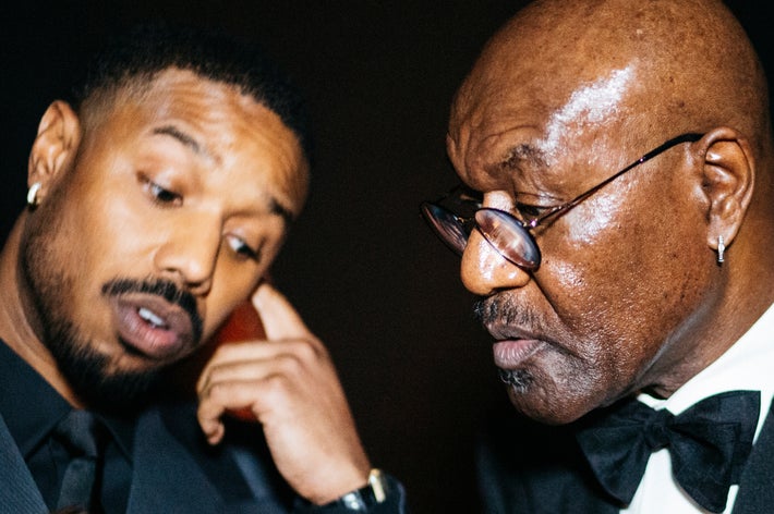 To menn i formelle dresser er i samtale på et arrangement. Den ene gestikulerer mens den andre lytter oppmerksomt