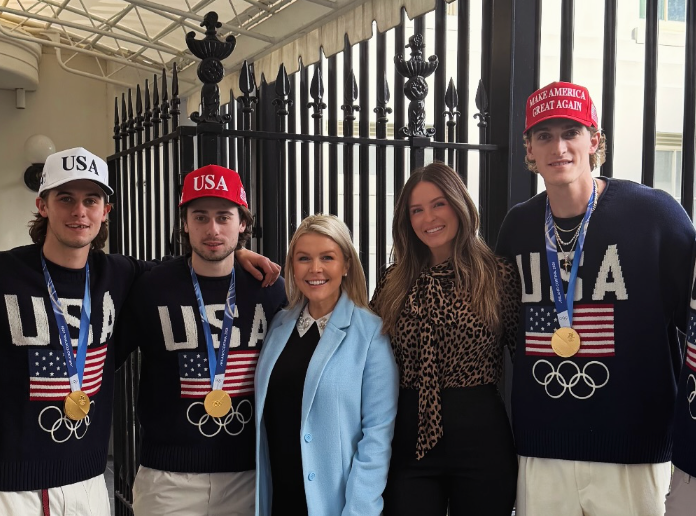 Gruppe på tre medaljevinnere i USAs OL-utstyr med to kvinner, en i blå frakk og en annen i en topp med leopardprint, poserer sammen