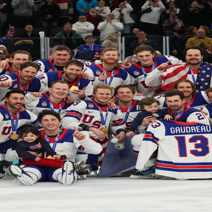 Gruppebilde av ishockeylaget USA, poserte på banen, med en trøye med "Gaudreau" og nummer 13, og feiret en seier