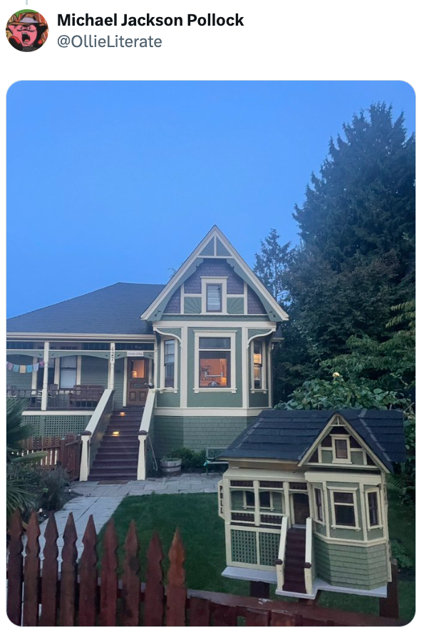 Et sjarmerende hus med et matchende dukkehus i forgården, satt mot et bakteppe av trær