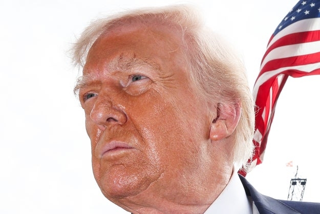 Mann i dress med et amerikansk flagg uskarpt i bakgrunnen