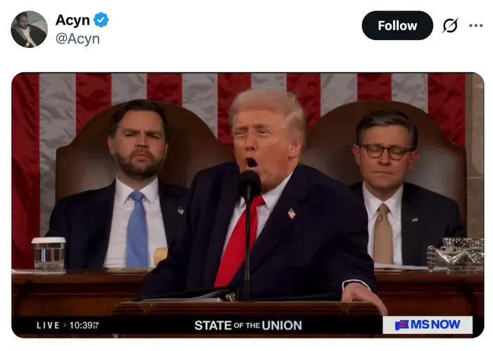 En person i dress taler ved et podium under State of the Union, med tjenestemenn som sitter bak dem