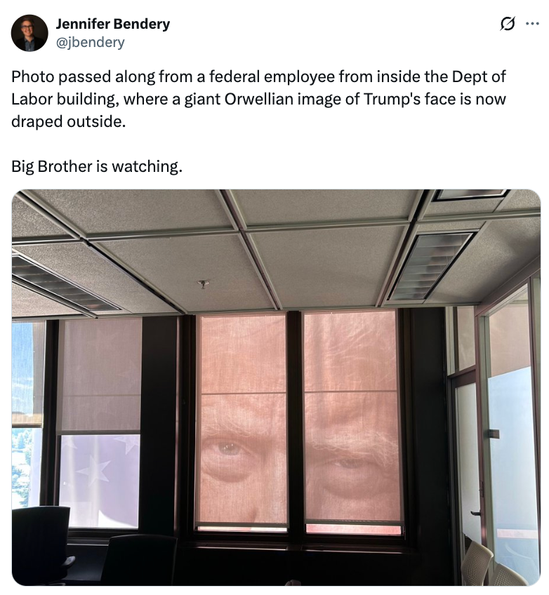 Rullegardiner på et kontor har et forstørret bilde av et ansikt, som ligner et overvåkingstema. Teksten ovenfor refererer til en "Orwellianer" display og "Big Brother."