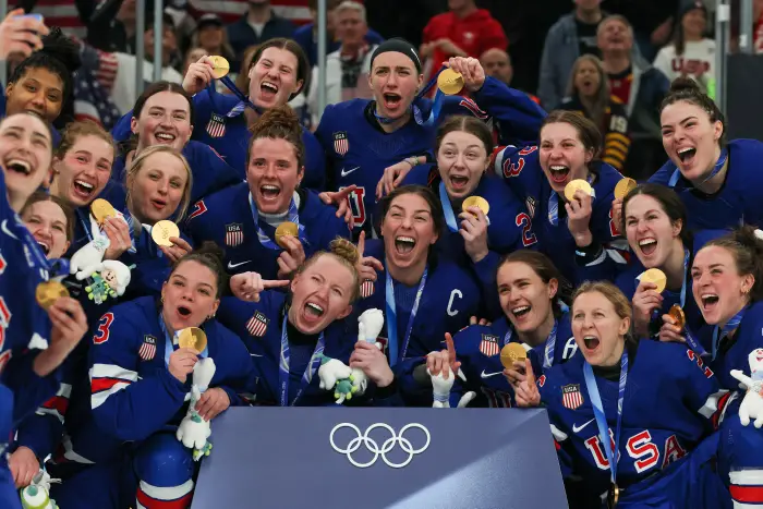 Amerikansk kvinnehockey feirer med gullmedaljer ved OL, smiler og poserer for et gruppebilde