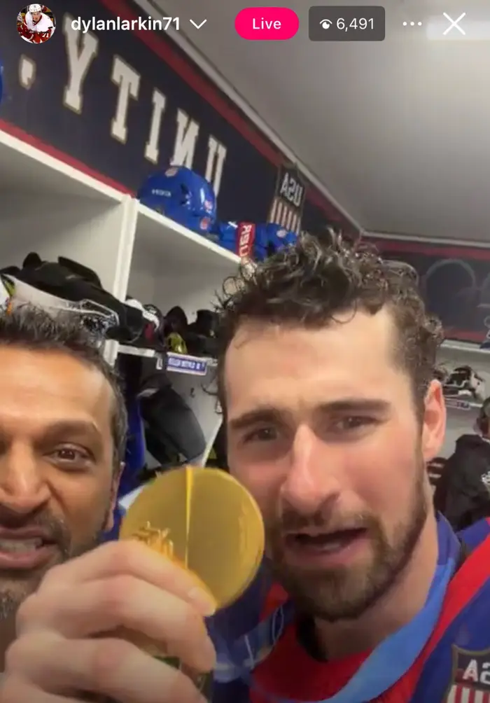 Kash Patel og Dylan Larkin i et lags garderobe; Dylan har en gullmedalje