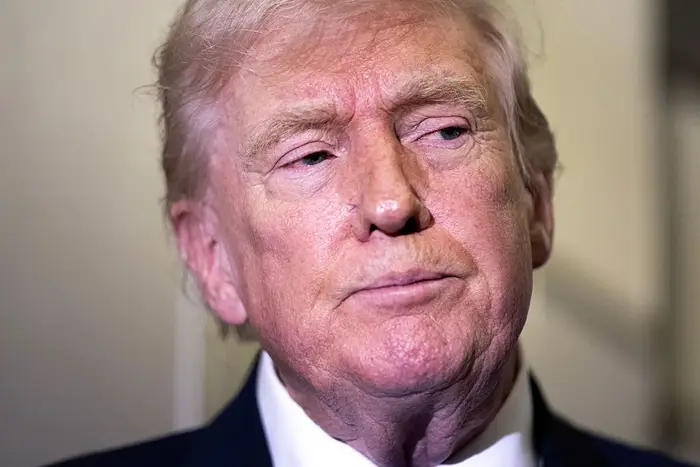 En mann i dress ser til siden med et nøytralt uttrykk