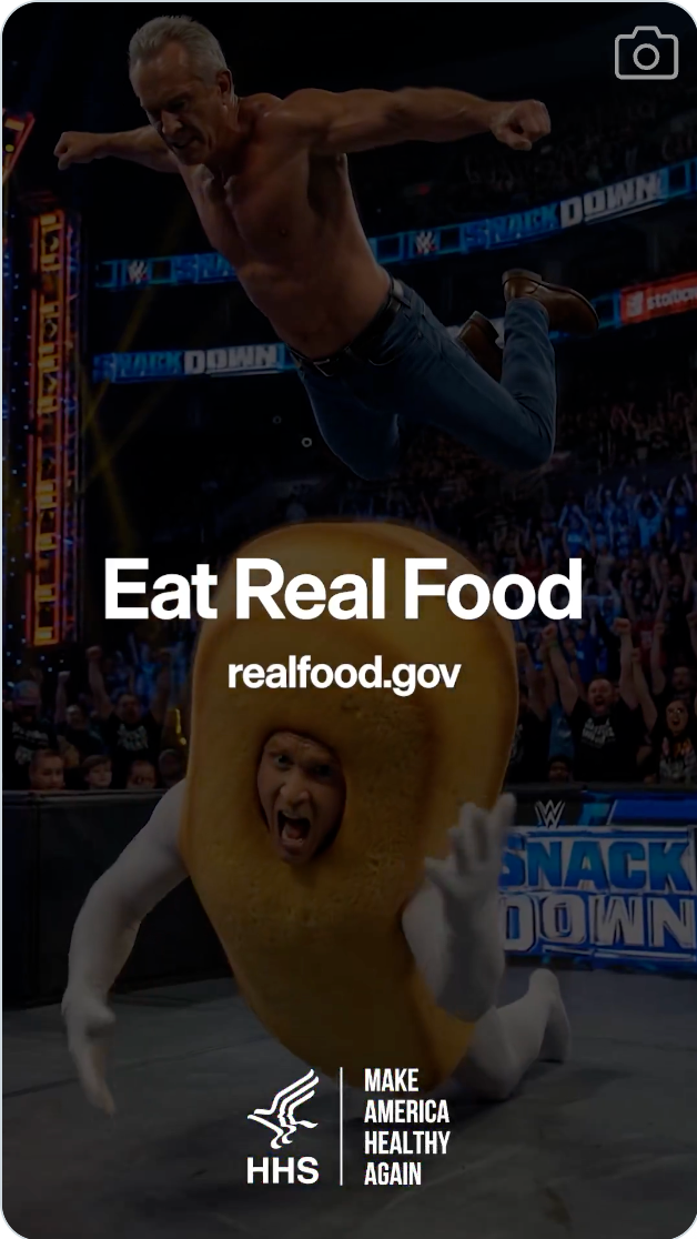 Person utfører et brytingstrekk på en maskotdrakt under en iscenesatt begivenhet. Tekst: 