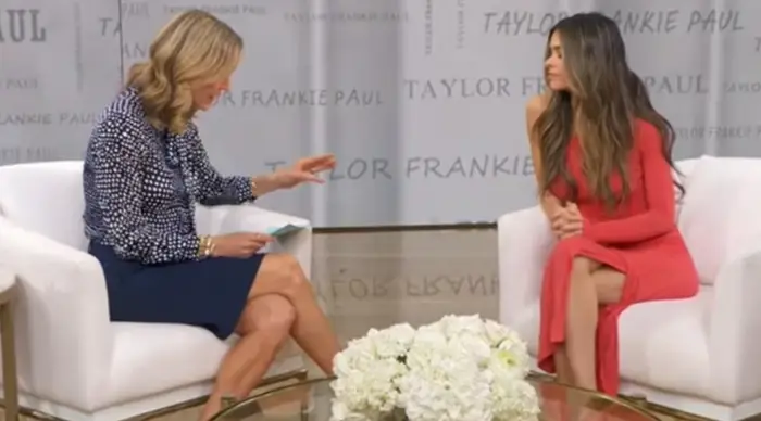 To personer satt i stoler under et TV-intervju på "GMA." Den ene har på seg en formell kjole, og den andre en lang kjole. "Taylor Frankie Paul LIVE PÅ GMA" er synlig