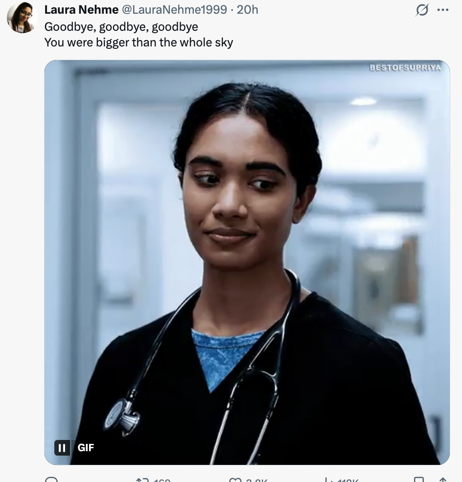 Karakter fra et TV-program smiler litt, iført en svart medisinsk skrubb og stetoskop, på sykehus.