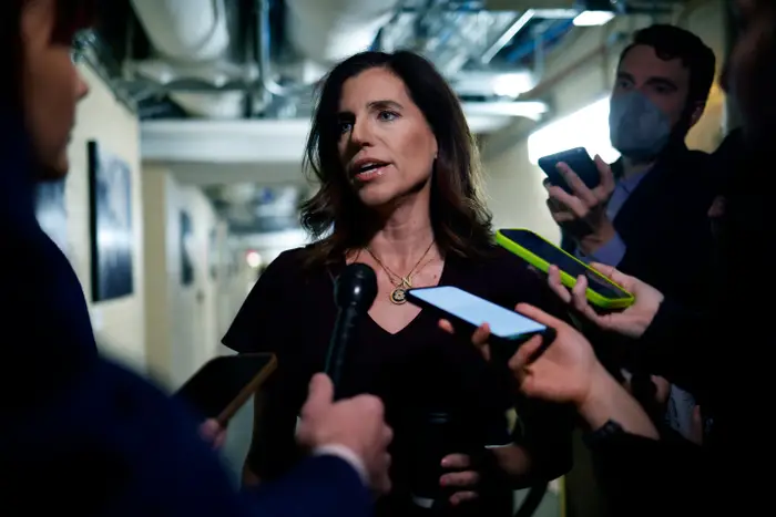 Nancy Mace snakker til journalister i en gang, omgitt av mikrofoner og telefoner